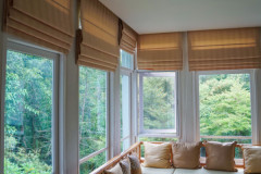 brown-roman-blind-shade-curtain-in-the-sunroom-with-tree-forest-mountain-background