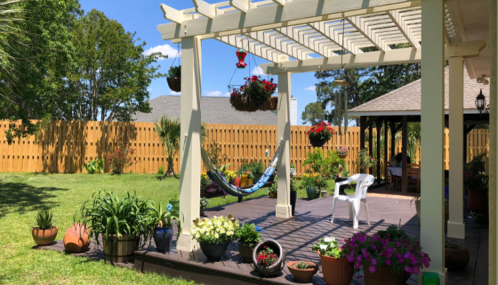 Beautiful backyard oasis with a shadow box fence and pergola on a sunny day