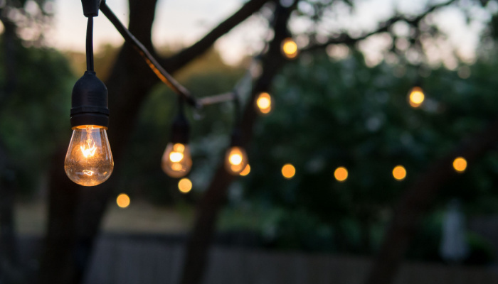 Beautiful Decorative outdoor string lights hanging on tree in the garden at night time