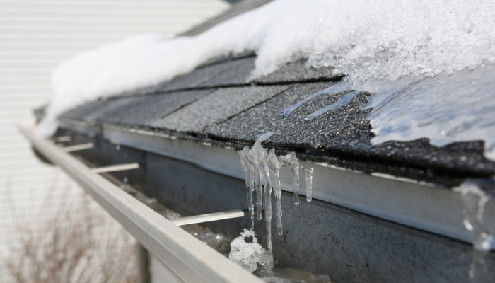 Ice on roof and gutters in winter season