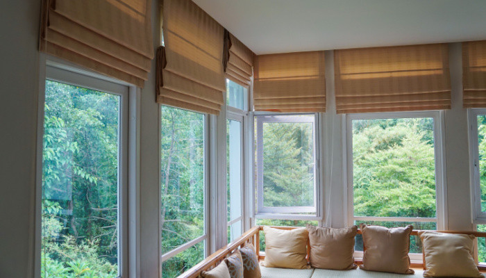 brown roman blind shade curtain in the sunroom with tree forest mountain background